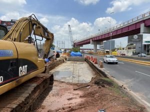 Se le añade y sobrepone otro carril elevado para corregir el Distribuidor Vial Universidad, y sube el costo de la obra